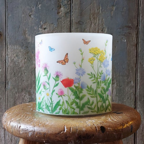 Candle Lantern with floral and butterfly design on a wooden stool against a wooden background