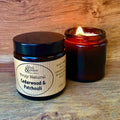 Scented candle and jar with 'Truly Natural Cedarwood & Patchouli' label on a wooden surface