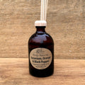 Amber bottle with wooden Geranium diffuser on a wooden background