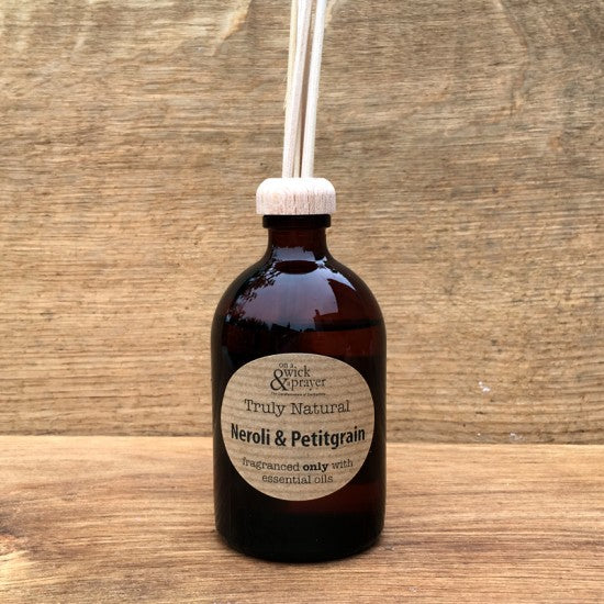 Bottle of Neroli & Petitgrain essential oil diffuser on a wooden surface