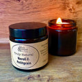 'Truly Natural Neroli & Petitgrain' amber jar candle lit on a wooden surface